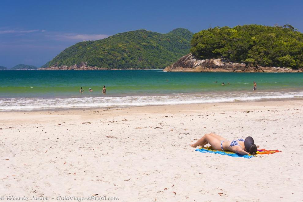 Imagem de uma moça tomando sol na Praia de Camburi.